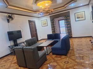 a living room with chairs and a table and a tv at Shore Manor in Supa