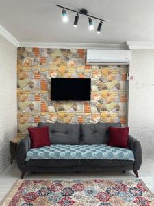 a couch in front of a stone wall with a television at Alha apart otel in Istanbul