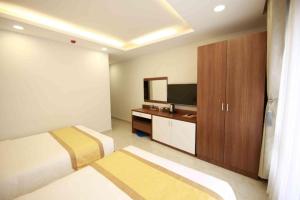 una camera d'albergo con un letto e una televisione di Kim Hoa Hotel a Da Lat