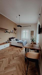 a bedroom with a bed and a table in it at Charming Studio Hideaway in the Heart of Liepaja in Liepāja