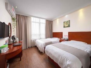 a hotel room with two beds and a desk at GreenTree Inn Yancheng Economic Development Zone Management Committee Express Hotel in Yancheng +202 photos