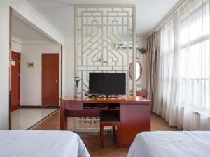 a bedroom with a desk with a computer on it at GreenTree Inn Yancheng Economic Development Zone Management Committee Express Hotel in Yancheng