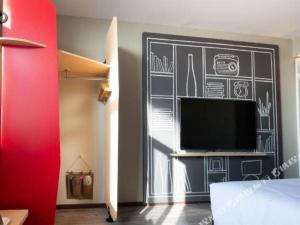 une chambre avec un mur en tableau noir avec une télévision à écran plat dans l'établissement Ibis Lianyungang Guanyun County Downtown Hotel Hotel, à Guanyun