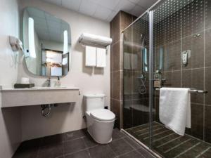 une salle de bain avec une douche, des toilettes et un lavabo dans l'établissement Ibis Lianyungang Guanyun County Downtown Hotel Hotel, à Guanyun