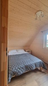 a bedroom with a bed in a wooden room at Dziupla u Szpaka in Kątno