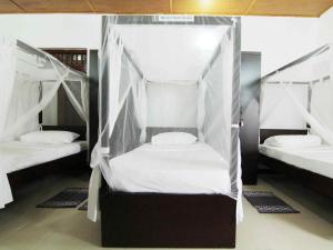 a bedroom with two beds with mosquito nets at 2in1 Kandy Hostel in Kandy