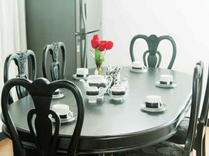 a black dining room table with red tulips on it at 2in1 Kandy Hostel in Kandy +36 photos