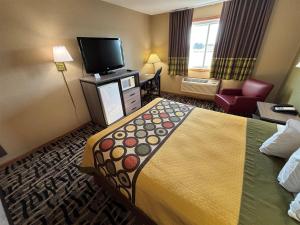 a hotel room with a large bed and a television at Super 8 by Wyndham McLean/Bloomington SW in McLean