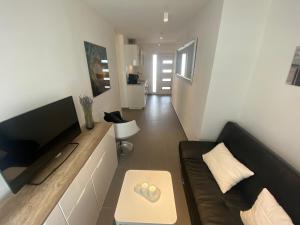 a living room with a couch and a flat screen tv at Apartments Katharina in Batalaži