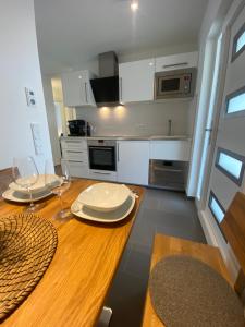 a kitchen with a wooden table with two plates on it at Apartments Katharina in Batalaži