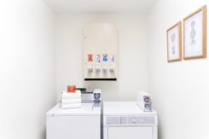 a white laundry room with a washer and dryer at Super 8 by Wyndham Montpelier in Montpelier