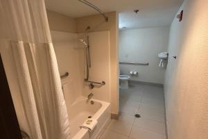a bathroom with a shower and a toilet and a tub at Travelodge by Wyndham Arlington/Dallas Area in Arlington +4 photos