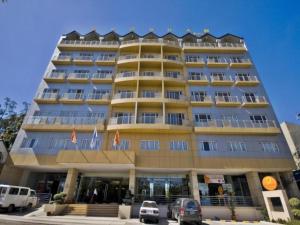 a large building with cars parked in front of it at Baguio Burnham Suites Hotel in Baguio