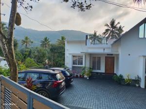 two cars parked in front of a house at Accadio Residency in Kattappana