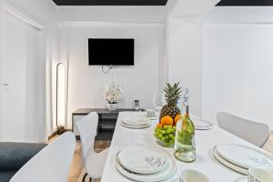 Un comedor blanco con una mesa y sillas blancas. en Blue Breeze Apartament, en Năvodari