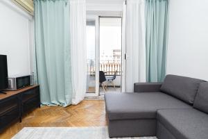 a living room with a couch and a television at Calea Victoriei View in Bucharest