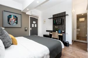 a bedroom with a bed and a desk and a bathroom at Rise Urban Art Hotel in Larnaca