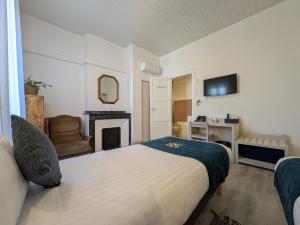 a bedroom with a bed and a fireplace and a television at Will's Hotel in Narbonne