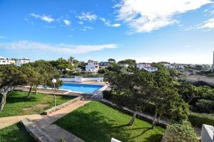 an aerial view of a backyard with a swimming pool and trees at Apartamento Calan Forcat in Ciutadella