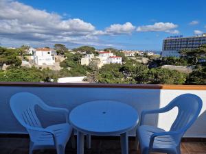 two blue chairs and a table on a balcony at Apartamento Calan Forcat in Ciutadella