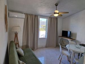 a living room with a couch and a table and a window at Apartamento Calan Forcat in Ciutadella