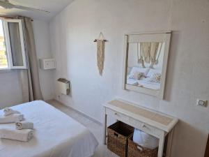 a white room with a bed and a mirror at Apartamento Calan Forcat in Ciutadella +12 photos