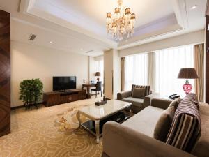 a living room with a couch and a tv at Inner Mongolia Hotel Forbidden City in Beijing