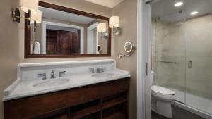 a bathroom with a sink and a toilet and a mirror at Disney's Yacht Club Resort in Orlando