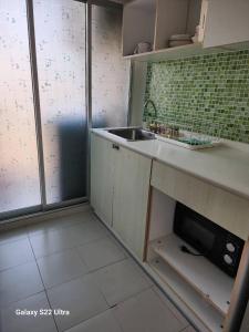 ホアヒンにあるBaan Peang Ploen Huahinのシンクと電子レンジ付きのキッチン