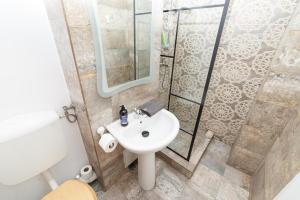 a bathroom with a white sink and a shower at Calea Victoriei View in Bucharest +28 photos