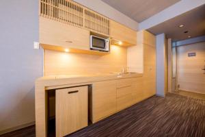 a kitchen with a sink and a microwave on a wall at RESI STAY Kumico Amaterrace in Kyoto