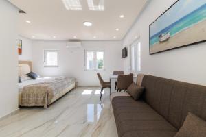 a bedroom with a bed and a couch and a tv at Premium Rooms Prince in Zadar +32 photos