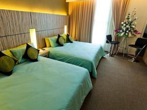 クチンにあるGrand Medallion Hotelのベッドが2つと花瓶が置かれたホテルの部屋 +101枚の写真