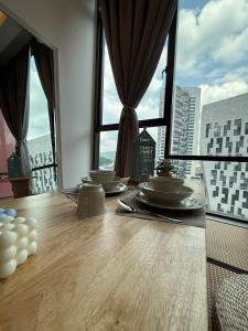 a table with dishes on it in a room with windows at Casa Boheme Empire Damansara in Petaling Jaya