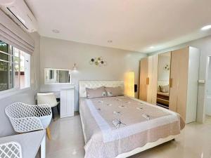 ein großes Schlafzimmer mit einem großen Bett und einem Stuhl in der Unterkunft Luxury 6BHK Villa with Private Pool in Pattaya by - OzyStays in Nong Prue + 38 Fotos