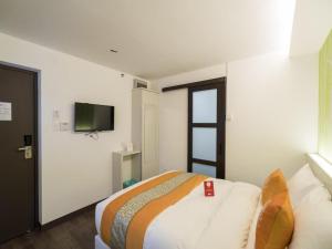a bedroom with a bed and a flat screen tv at OYO 264 City Edge Hotel in Kuala Lumpur