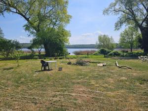a park with a bench and a table in the grass at Poddasze nad jeziorem Piaski in Wolin