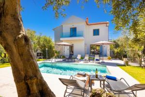 a villa with a swimming pool and a house at Villa Nineta in Tavronitis