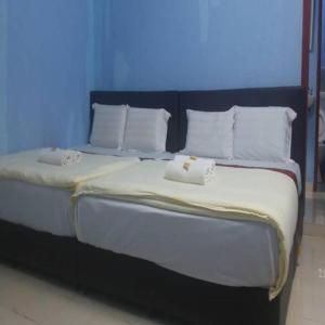 a large bed with white sheets and pillows at Mawanza Motel in Langkawi Islands
