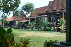 una casa con delle palme davanti di OYO Home 90745 Desa Balqis Beach Resort a Malacca
