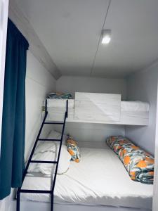 a dorm room with two bunk beds and a ladder at Mobile home sunshine in Drage