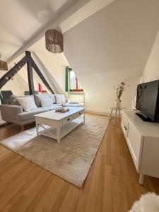 a living room with a white couch and a table at Charme et Confort, plein centre in Obernai +8 photos