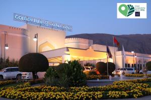 un centro commerciale con macchine parcheggiate di fronte di Golden Tulip Nizwa Hotel a Nizwa