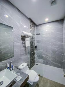 a bathroom with a toilet and a sink and a shower at The South Hideaway Oslob 