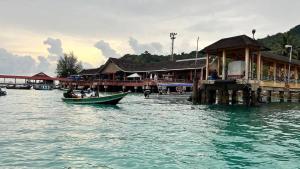 a small boat in the water near a dock at Perhentian Asma in Kampung Kuala Besut