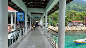 a bridge over a river with people walking on it at Perhentian Asma in Kampung Kuala Besut