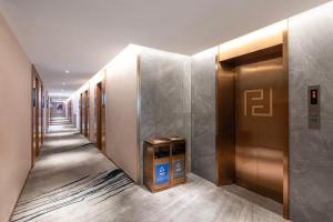 a hallway with elevators in a building at Fanyuan Hotel Zhujiang New City Guangzhou in Guangzhou