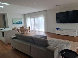 a living room with a couch and a table with chairs at Songlark Street, 54 in Bermagui