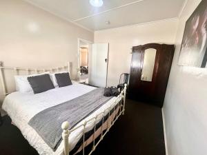 una camera da letto con un grande letto bianco in una stanza di Denham Cottage - Quart Pot Creek a Stanthorpe Altre 2 foto