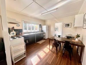una cucina e una sala da pranzo con tavolo e sedie di Denham Cottage - Quart Pot Creek a Stanthorpe